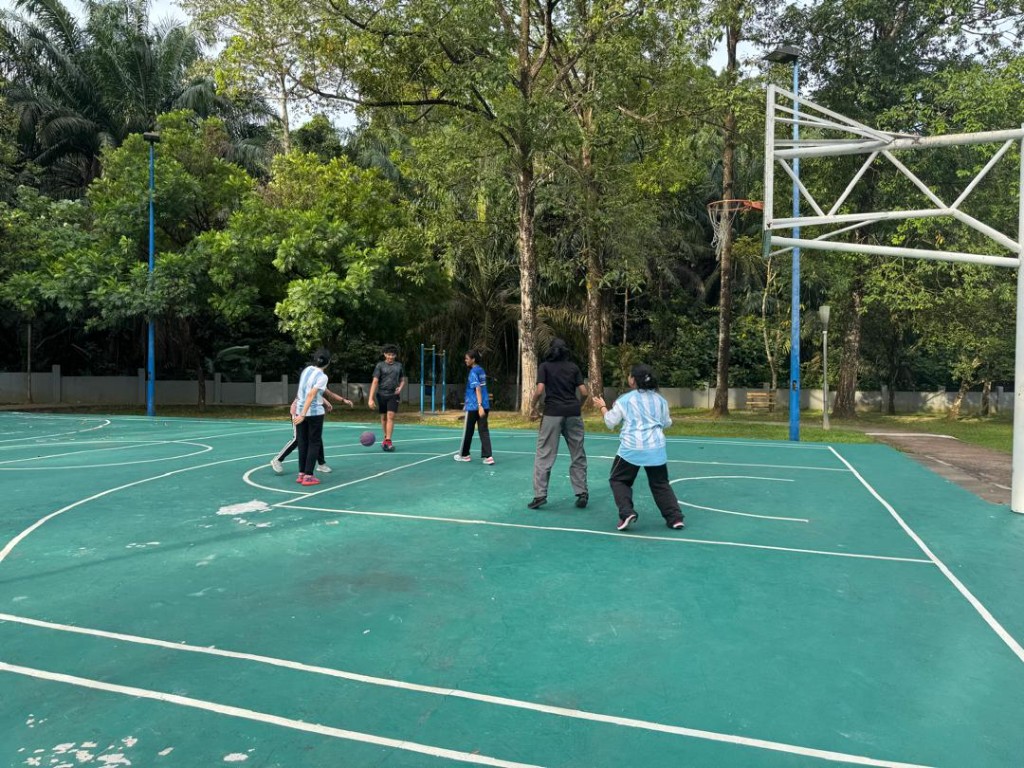 Team drills on a green outdoor basketball court